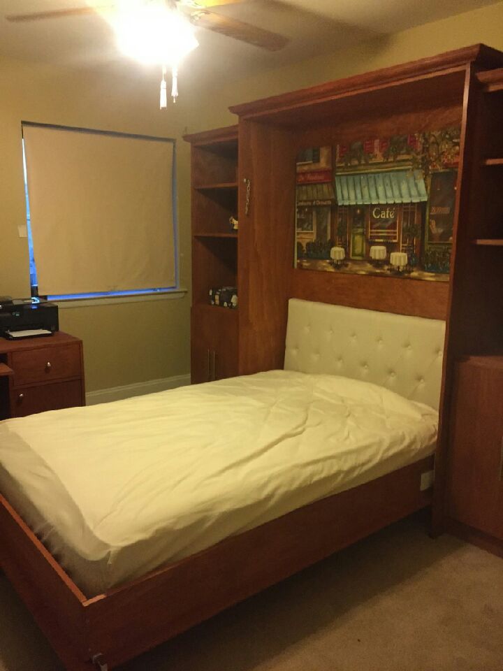 Full-size Verticla Murphy Bed opened with wood veneer custom stain raise panels crown molding with bookcases