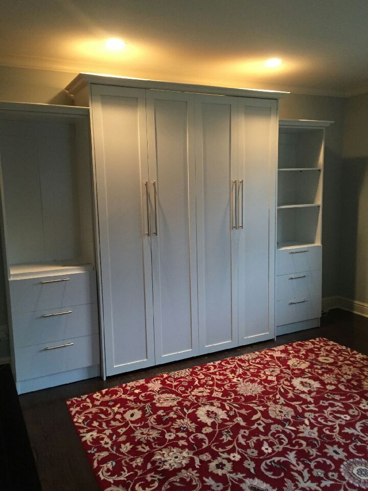 Queen Sized Murphy Bed with raised panels and custom bookcases and drawers.